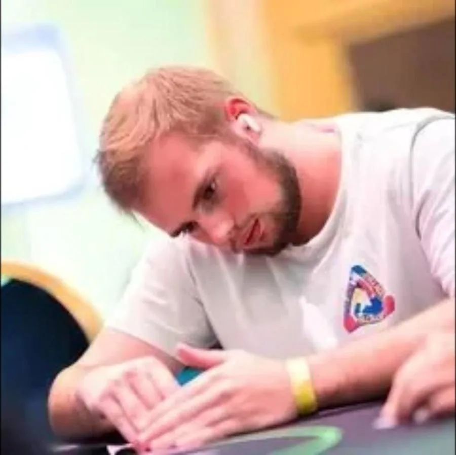 A student studying his cards at a live poker tournament