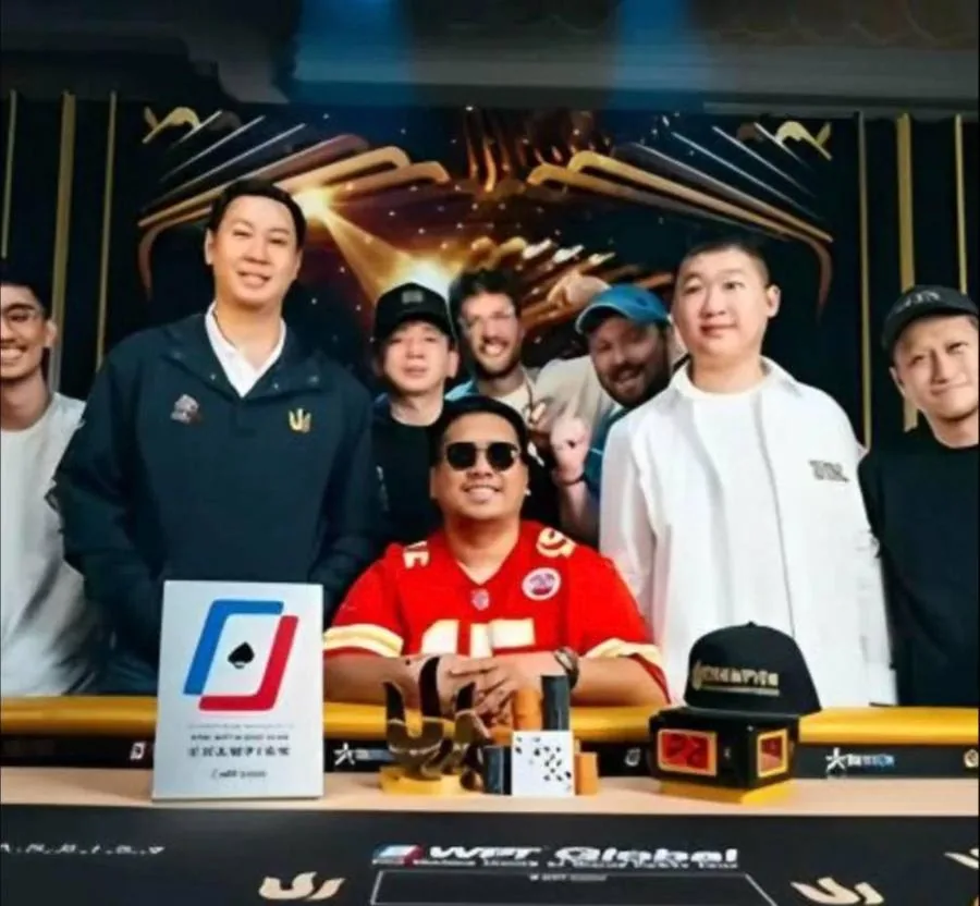 A Thomas Boivin student celebrating a Triton Poker title with friends and the trophy